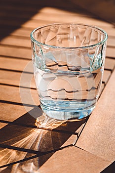 A transparent glass of crystal clean water on the wooden table