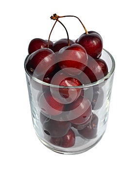 Transparent glass cup filled with ripe juicy cherries