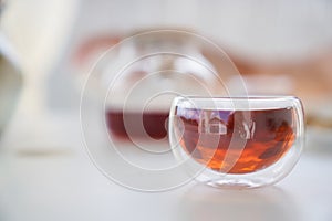 Transparent glass Cup of tea in nature. The concept of breakfast in the backyard of the house. Early morning, tea and