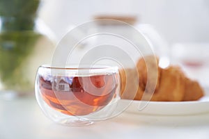 Transparent glass Cup of tea in nature. The concept of breakfast in the backyard of the house. Early morning, tea and