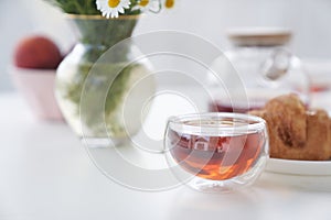 Transparent glass Cup of tea in nature. The concept of breakfast in the backyard of the house. Early morning, tea and