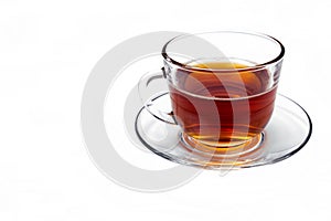 Transparent glass cup with tea on a saucer isolated