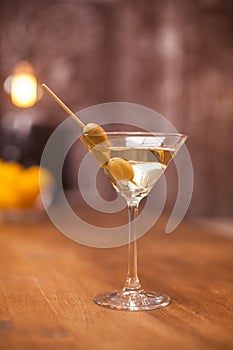 Transparent glass filled up with dry white martini on a counter bar