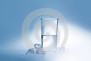 A transparent glass filled with water and ice. Freshness and cleanliness.