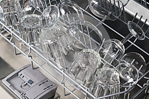 Transparent glass goblets in the dishwasher compartment, close-up top view