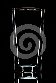 Transparent glass on lumen on black background and black surface. studio photo. macro