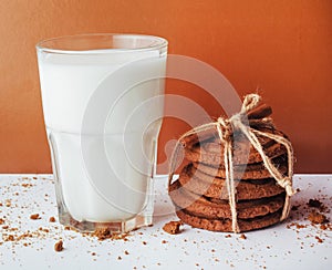 Transparent glass of milk and cookies on a white background