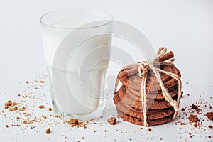 Transparent glass of milk and cookies on a white background