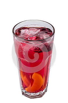Transparent glass of red refreshing summer drink with sliced lemon, peach and ice cubes isolated on a white background