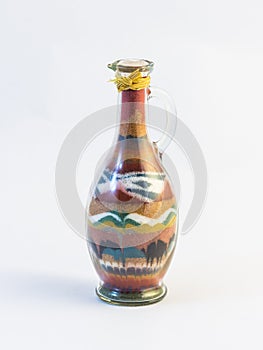 Transparent glass sealed jug with pattern of colored sand inside