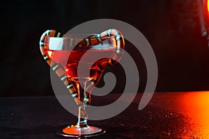 Transparent glass with a snake against a dark background. close up. liquid in a glass