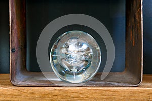 Transparent glass sphere or orb displayed on a shelf