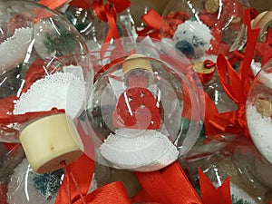 Transparent glass spheres with artificial snow and red figures of a cap.