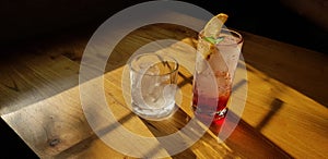 Transparent Glasses with sweet drinks inside with colorful drink, with shadow and table background with ice cubes