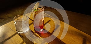 Transparent Glasses with sweet drinks inside with colorful drink, with shadow and table background with ice cubes