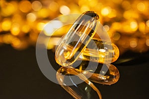 Transparent gold capsules on a dark background. Omega