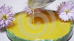 Transparent Honey Pours from a Spoon into a Lid, a Bowl. Close-up. 4K