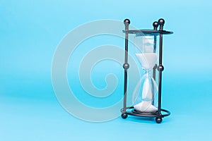Transparent hourglass, Blue background. On the right. Copy, text space
