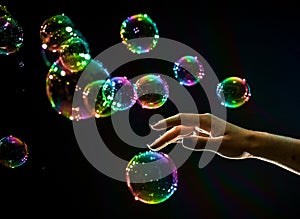 The transparent, iridescent soap bubbles isolated on black.