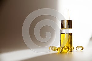 Transparent jar with oil and medical capsules on a white background in the sun. Products CBD