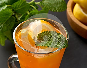 Transparent large glass with a handle filled with lemonade with slices of orange and lemon