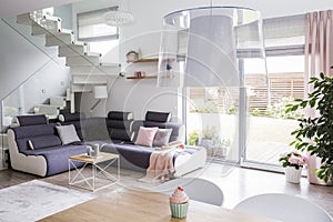 Transparent light shade above a wooden dining table in a white l