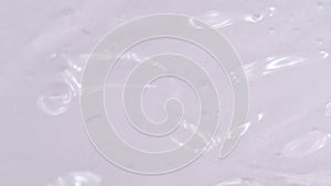 Transparent liquid spreads over a background. Gel texture with bubbles.