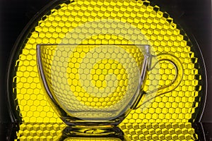 transparent mug on a background of yellow honeycomb for photography