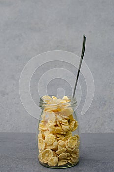 Transparent packaging with cornflakes on a gray background