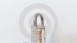 Transparent padlock rotating on white background