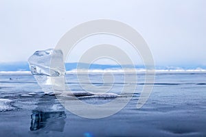 A transparent piece of ice on surface of blue lake Baikal