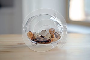 Transparent piggy bank with coins. Glass moneybox filled with coins. Deposit, saving money, investment concept. Family budget,