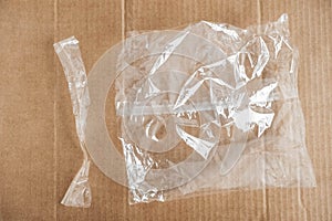 Transparent plastic bag on a cardboard background. Top view, copy space. Packaging conce