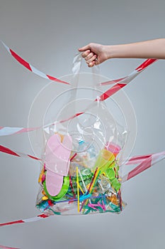Transparent plastic bag with plastic straws and flip flops photo