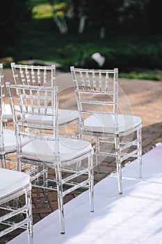 Transparent plastic chairs at a wedding ceremony in a row