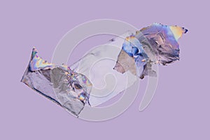 Transparent plastic film, rainbow colored by photoelasticity isolated on light purple background