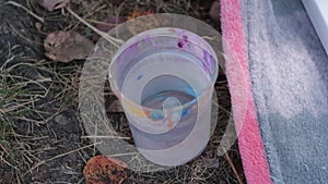 Transparent plastic glass of water mudded by brushes