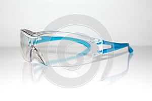 Transparent plastic safety goggles glasses for dust and spark protection for your eyes isolated on white background