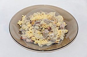 Transparent plate with pasta spaghetti carbonara with cream, mushrooms, bacon