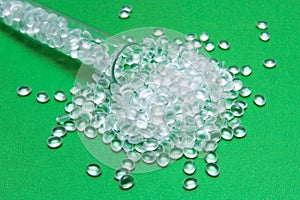 Transparent Polyethylene granules on a green background.The concept of free bpa. HDPE Plastic pellets. Plastic Raw material . ID photo