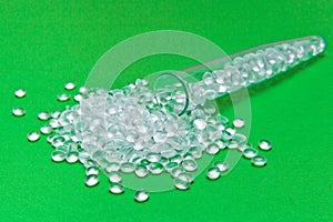 Transparent Polyethylene granules on a green background.The concept of free bpa. HDPE Plastic pellets. Plastic Raw material . ID