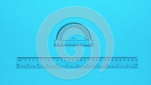 Transparent protractor and transparent ruler on a blue background