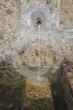 Transparent running water fountain with stone background in Candelario, Salamanca, Castilla Leon, Spain, Europe.