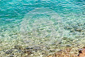 Transparent sea surface at a stony seashore