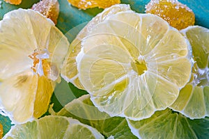 Transparent slices of lemon and peel on a blue surface. Healthy vegetarian food. Top view.