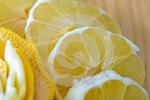 Transparent slices of lemon and peel on a cutting wooden board and blue surface. Healthy vegetarian food.