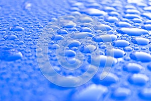 Transparent still water drops on light blue background. Blue water drops. Drops of rain on glass. Blue abstract water drop backgro