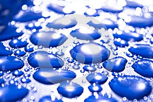 Transparent still water drops on light blue background. Blue water drops. Drops of rain on glass. Blue abstract water drop backgro