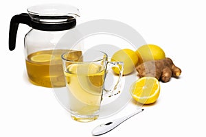 Transparent teapot and mug of herbal tea, lemons, ginger, thermometer on white background. Cold and flu season concept