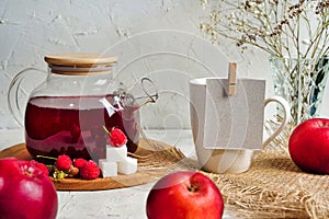 Transparent teapot with red tea with raspberries and apples. Detox antioxidant home health drink. Copy space